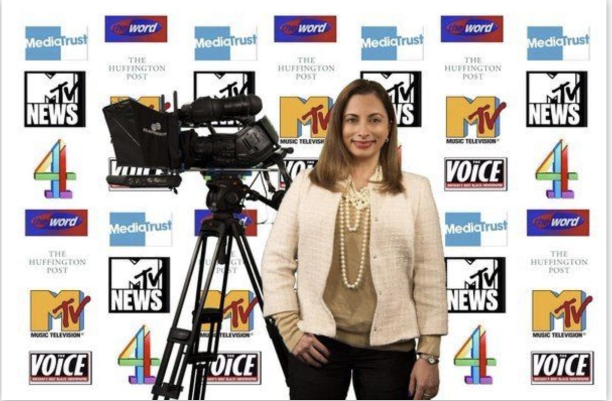 Jasmine Dotiwala beside a broadcast camera in front of a backdrop of MTV, Channel 4, Media Trust, The Voice and Huffington Post logos